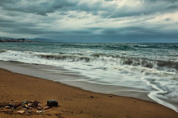 Overcast evening in Barcelona beach, waves and stormy clouds
