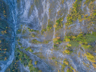 Aerial view of gorge in mountain area with river through forest