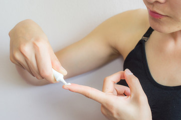 Portrait of young Asian woman having acne problem. Preparing for applying acne cream on her fingers.