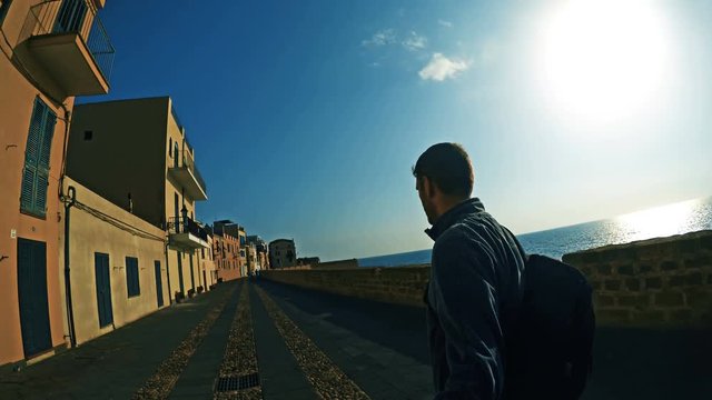 Man walking in Alghero seafront. Sardinia, Italy