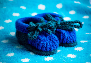 Fototapeta na wymiar Blue children's knitted shoes. Preparing children for the cold winter. Handmade children's shoes