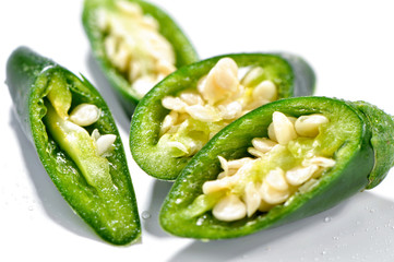 chopped green chili pepper macro isolated on white background sprinkle with water
