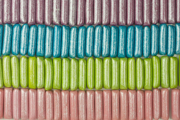 background of gummy candy in mermaid colors dusted with silver