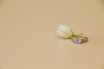 Wedding ring and jasmine  flower flat lay on pink background. Gold ring and jasmine