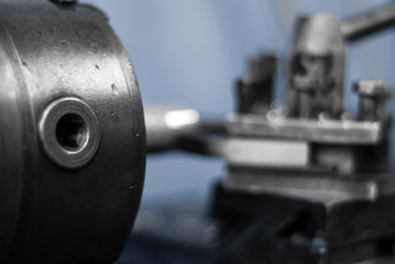background - detail of the machine, the spindle of turning lathe while working close up, the background is blurred
