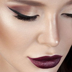 Luxurious young woman with perfect make-up with purple lipstick