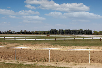 Hippodrome horse racing area with green grass and white fences landscape
