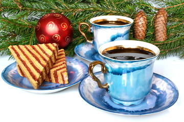 couple vintage elegant stylish graceful beautiful porcelain cup with golden handle of morning tea or coffee and saucer with biscuit on background of fir branches with red Christmas ball and cone
