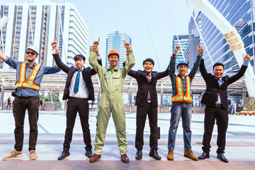 Happy engineer and business man teamwork are join hand up to goal and success on city background,...