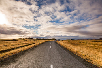 Road through iceland landscape. Road and car travel scenic and sunset.Road travel concept.Car...