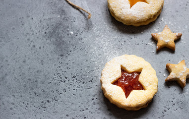 Christmas or New Year homemade cookies with red and orange jam. Flat lay. Traditional Austrian Christmas cookies - Linzer biscuits filled with jam. Top view. Copy space.