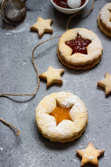 Christmas or New Year homemade cookies with red and orange jam. Flat lay. Traditional Austrian Christmas cookies - Linzer biscuits filled with jam. Top view. Copy space.