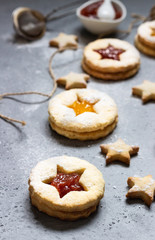 Christmas or New Year homemade cookies with red and orange jam. Flat lay. Traditional Austrian Christmas cookies - Linzer biscuits filled with jam. Top view. Copy space.