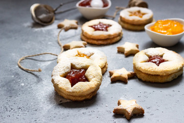 Christmas or New Year homemade cookies with red and orange jam. Flat lay. Traditional Austrian Christmas cookies - Linzer biscuits filled with jam. Top view. Copy space.
