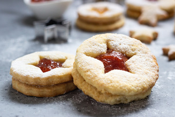 Christmas or New Year homemade cookies with red and orange jam. Flat lay. Traditional Austrian Christmas cookies - Linzer biscuits filled with jam. Top view. Copy space.