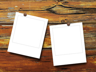Two blank square instant photo frames on brown old weathered wooden boards background