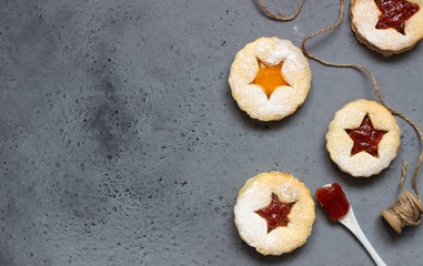 Christmas or New Year homemade cookies with red and orange jam. Flat lay. Traditional Austrian Christmas cookies - Linzer biscuits filled with jam. Top view. Copy space.
