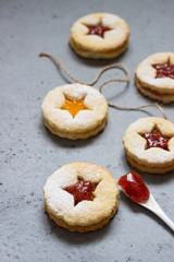 Christmas or New Year homemade cookies with red and orange jam. Flat lay. Traditional Austrian Christmas cookies - Linzer biscuits filled with jam. Top view. Copy space.