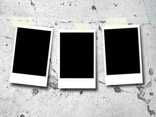 Three blank rectangular instant photo frame on old weathered concrete wall background