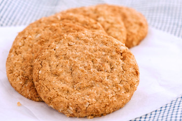 Homemade shortbread cookies made of oatmeal are stacked on white paper on the cloth background. Concept food healthy snack for enjoy in holiday.