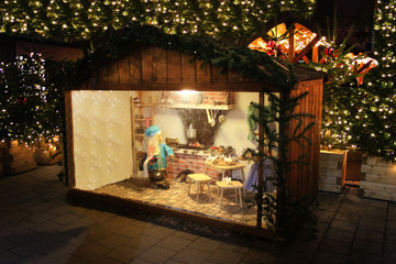 Illuminated Christmas market fair kiosk. Sale of mulled wine, Christmas trees and gingerbread