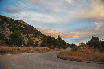 Serpentine road turning between mountains going to the top
