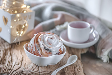 Delicious homemade sweet buns with cinnamon and icing sugar Christmas at the old wooden table. Traditional Swedish pastries, kanelbullar