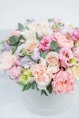 Beautiful spring bouquet in round box. Arrangement with various flowers. The concept of a flower shop. A set of photos for a site or catalogue. Work florist.