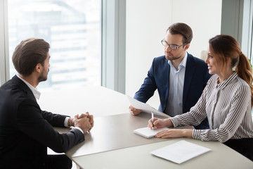 Two hr managers talking with candidate for vacancy. Job seeker at job interview answering questions...