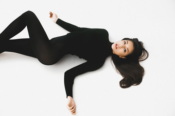 Young elegant girl posing in black pantinos and black sweater