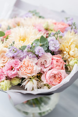 Beautiful spring bouquet in glass vase. Arrangement with various flowers. The concept of a flower shop. A set of photos for a site or catalogue. Work florist.