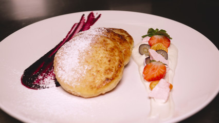 Homemade pancakes in a restaurant (at home) with jam and fruit are sprinkled with icing sugar. Concept from: Pancakes, Homemade, Restaurant, Fresh, Fruit, Jams, Icing Sugar, Strawberries, Cheesecakes.