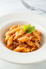 Piatto di mezze penne con ragù alla bolognese e formaggio grattugiato