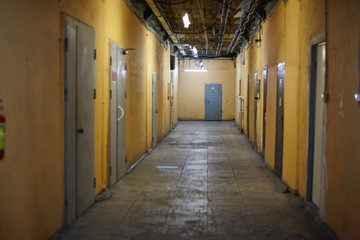 Interior of simple empty corridor with cement floor and doors in electric light
