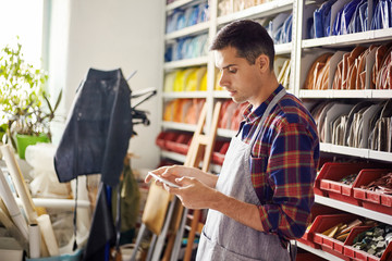 Artist using tablet in colorful workshop