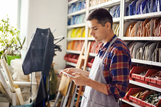 Artist using tablet in colorful workshop