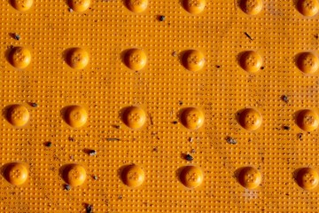 A close view of the yellow crosswalk pad on the street.