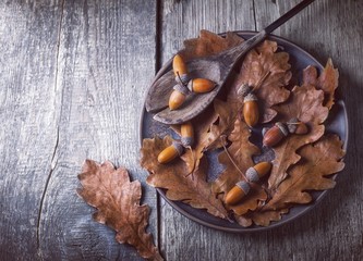 Autumn leaves on clay plate. Wooden table 