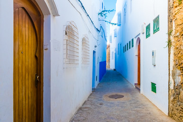 Door and beautiful street of white ancient medina of the Asilah village in Morocco