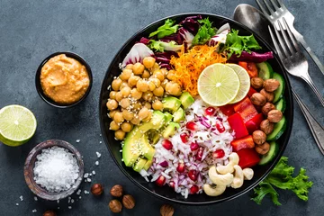 Wall murals meal dishes Healthy vegetarian Buddha bowl with fresh vegetable salad, rice, chickpea, avocado, sweet pepper, cucumber, carrot, pomegranate and nuts closeup