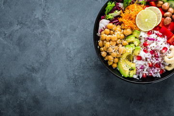 Healthy vegetarian Buddha bowl with fresh vegetable salad, rice, chickpea, avocado, sweet pepper,...