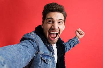 Portrait of a cheerful young man dressed in denim jacket