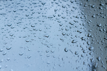 Cold shiny drops of autumn rain on the window pane in rainy autumn weather. Cool background with a...