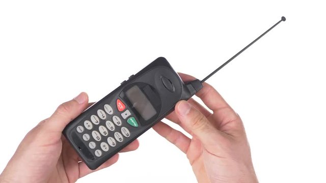 Old vintage cell mobile phone being used against white background