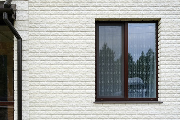 Drainpipe next to the window. Cottage with large panoramic Windows. Glazing of the facade.
