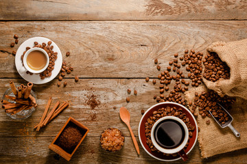 Top view of espresso shot and a cup of americano with coffee bean bag, sugar and cinnamon on wood background floor