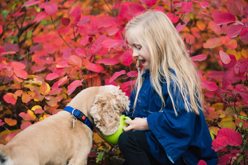 Happy small girl with cocker spaniel outdoors