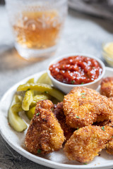 Fried crispy chicken nuggets with ketchup and pickles
