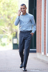 young businessman walking and talking with cellphone