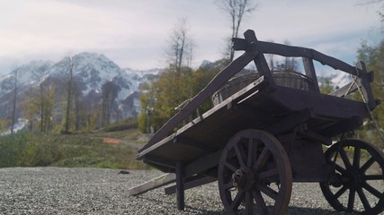 Fototapeta premium A cart without a horse in the mountains. A cart on the background of the mountains. Cart on the background of mountains. Two-wheeled cart on the background of mountains.